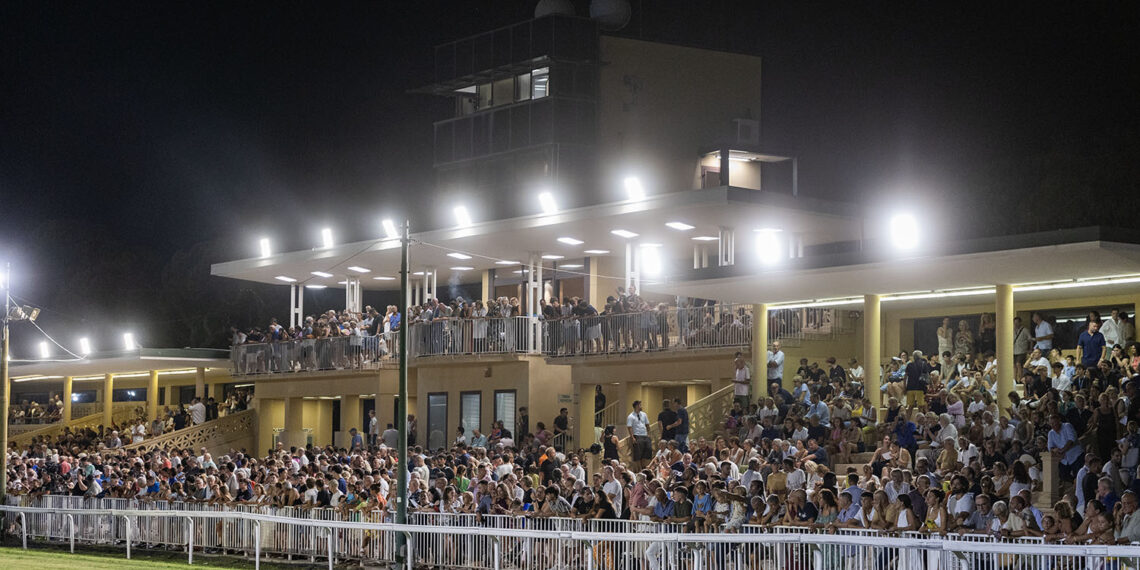 Il folto pubblico assiste in notturna all’81ª Coppa del Mare dalle tribune dell’ippodromo Federico Caprilli di Livorno