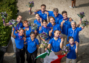 La squadra italiana di Volteggio mostra le medaglie e i bouquet conquistati ai FEI World Championships di Aachen 2026, posando con lo staff e la bandiera tricolore